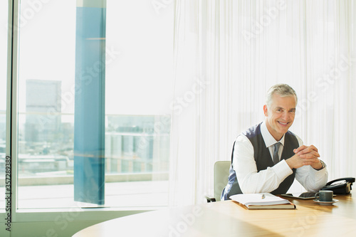 Businessman smiling at desk in office