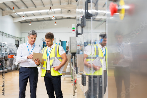 Obraz na płótnie Supervisor and worker using digital tablet in factory