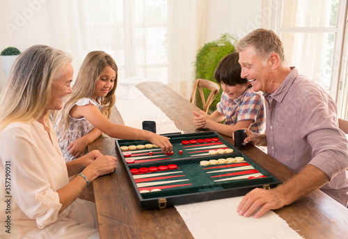 Canvas Print Grandparents and grandchildren playing backgammon