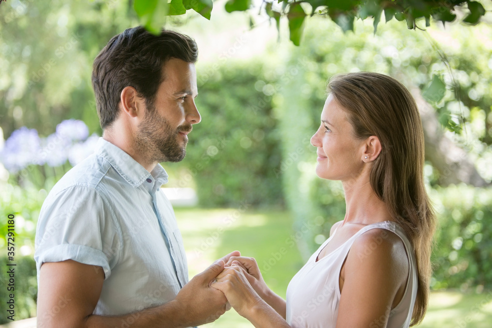 Couple holding hands face to face in garden Couple holding hands face to face in garden
