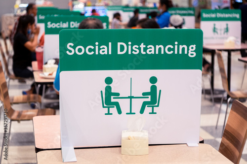 Social Distancing sign board stand on the table in food center of  supermarket