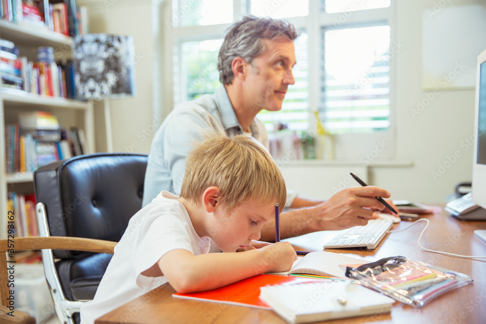 Father and son working in home office Father and son working in home office