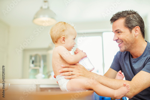 Father feeding baby in kitchen