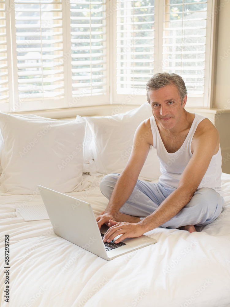 Man using laptop on bed Man using laptop on bed
