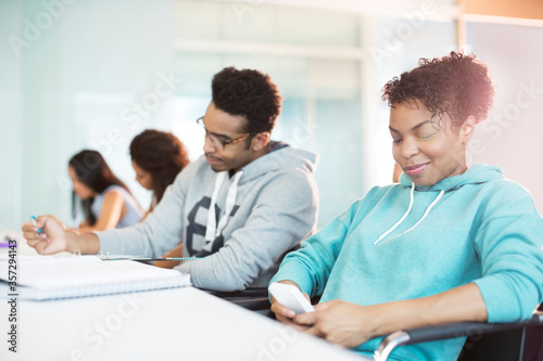 Tablou pe pânză University student using cell phone in classroom
