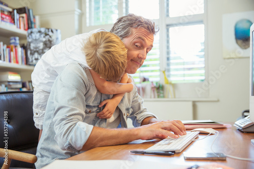 Boy hugging working father