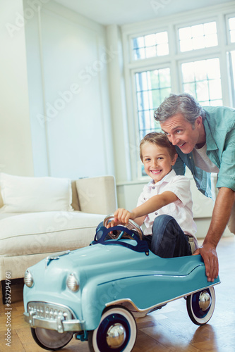 Cuadro en lienzo Father pushing son in toy car