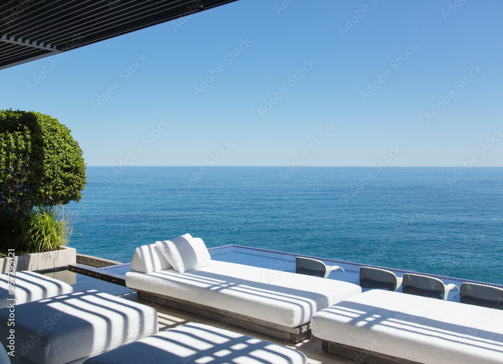Fototapeta premium Sofas and infinity pool overlooking ocean