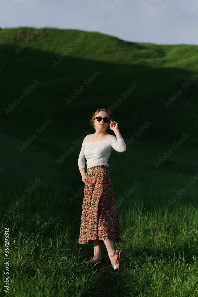 Beautiful woman wearing sunglasses and colorful clothes in sunny summer scenery. High quality photo Beautiful woman wearing sunglasses and colorful clothes in sunny summer scenery. High quality photo