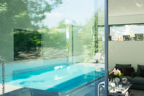 Swimming pool reflected in glass windows of modern house