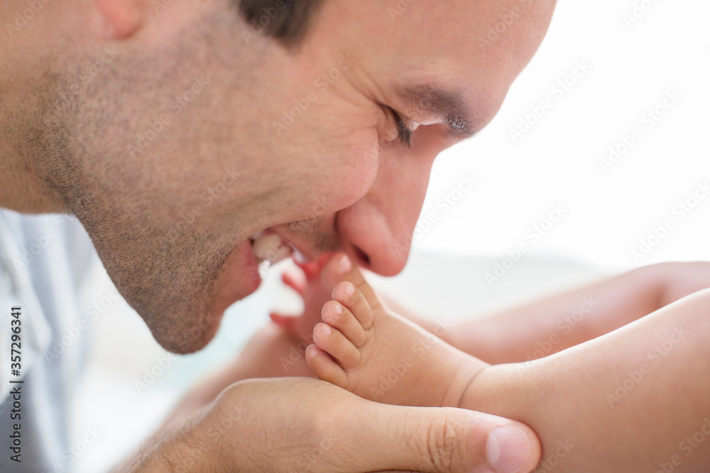 Father kissing baby boy's feet