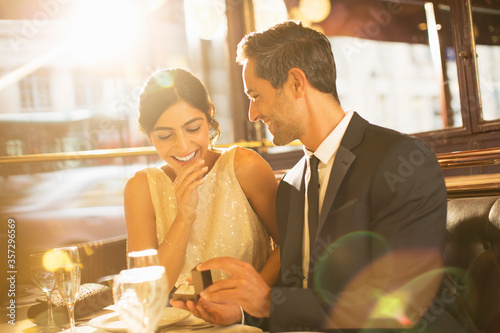 Man proposing to girlfriend in restaurant