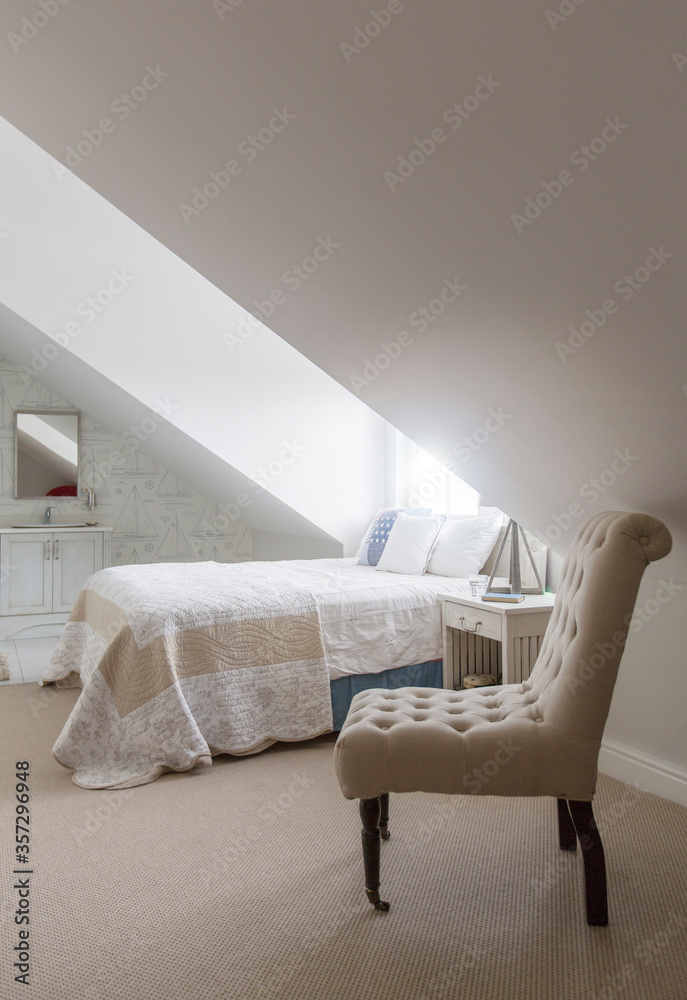 Bed under window in attic bedroom - obrazy, fototapety, plakaty 