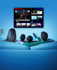 Family watching television in living room