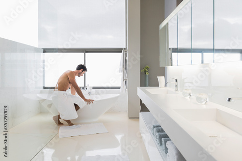 Man in towel preparing bath