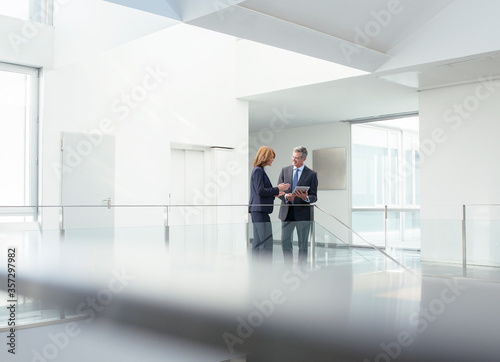 Business people with digital tablet in office corridor