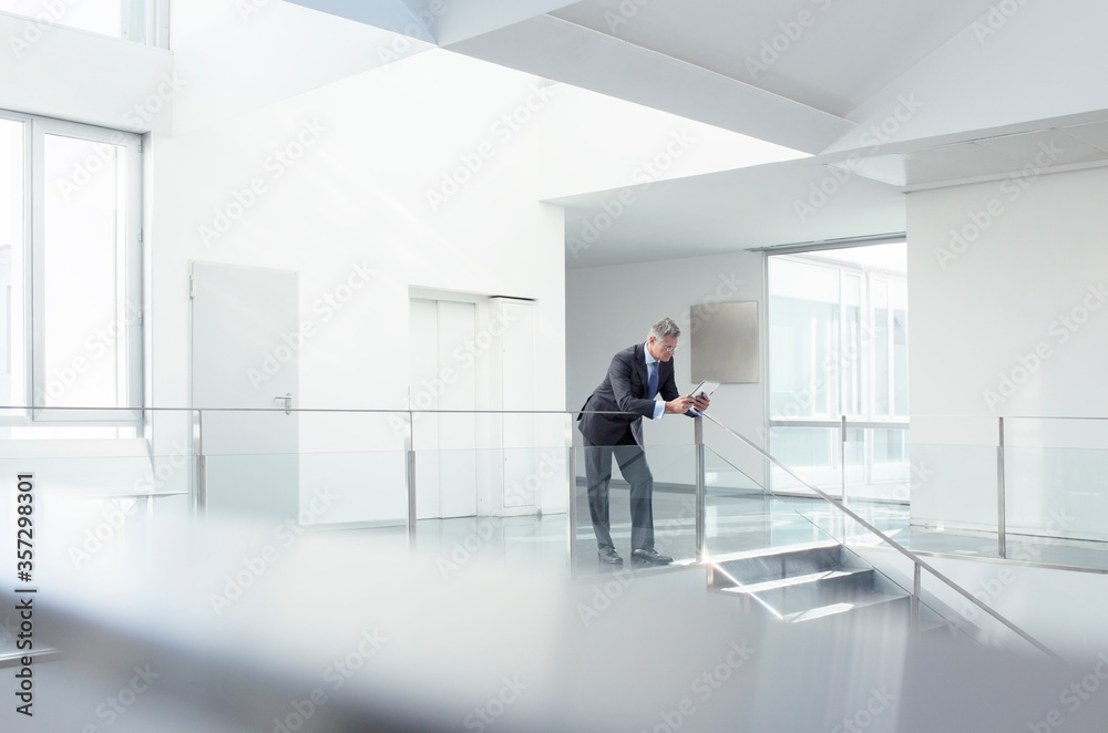 Fototapeta premium Businessman using digital tablet in corridor