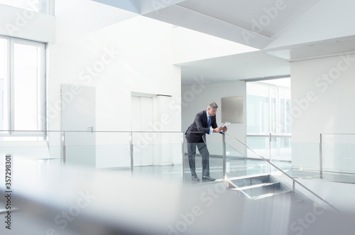 Businessman using digital tablet in corridor