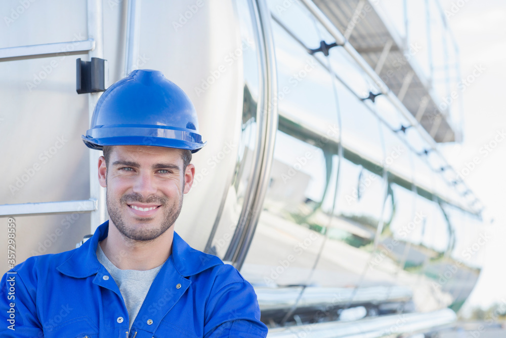 Portrait of smiling worker at back of stainless steel milk tanker Portrait of smiling worker at back of stainless steel milk tanker