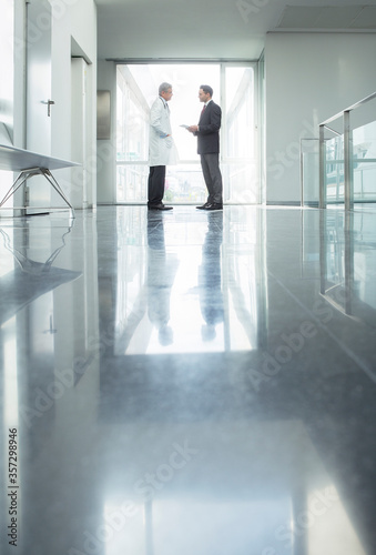 Doctor and administrator talking in hospital corridor