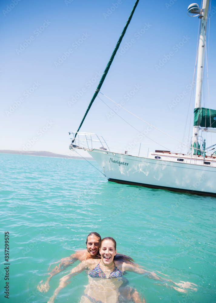 Couple swimming in water near boat 