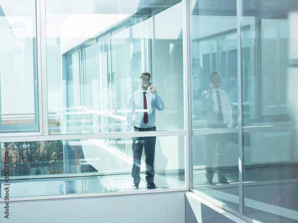 Businessman talking on cell phone in modern office Businessman talking on cell phone in modern office