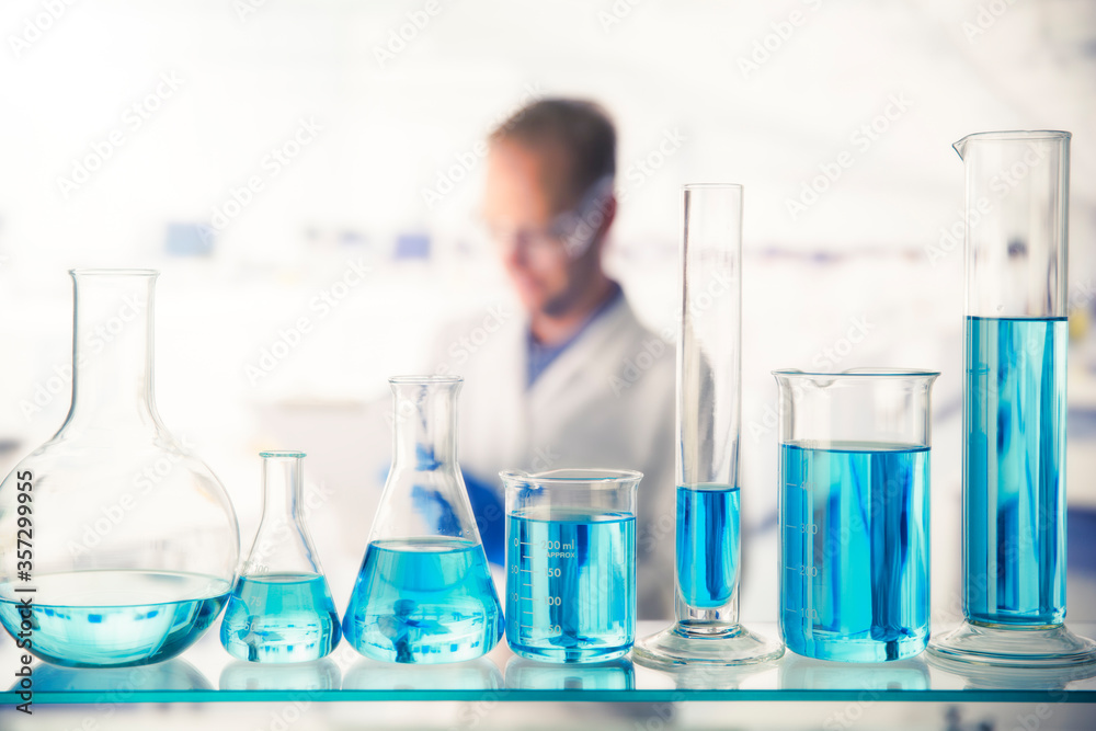 Close up of various solutions in beakers on shelf in lab Close up of various solutions in beakers on shelf in lab