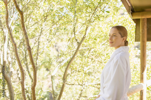 Woman wearing bathrobe on balcony