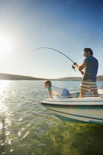 Father and son fishing on boat 