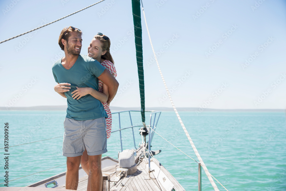 Couple hugging on deck of sailboat Couple hugging on deck of sailboat