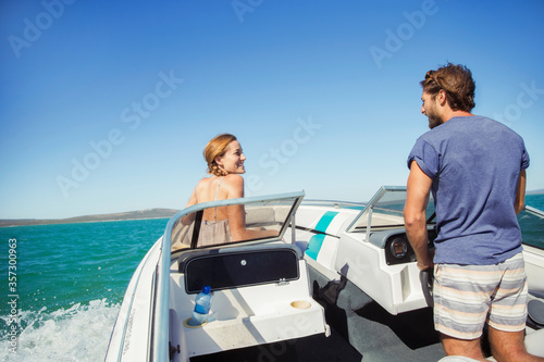 Man steering boat with girlfriend © Robert Daly/KOTO