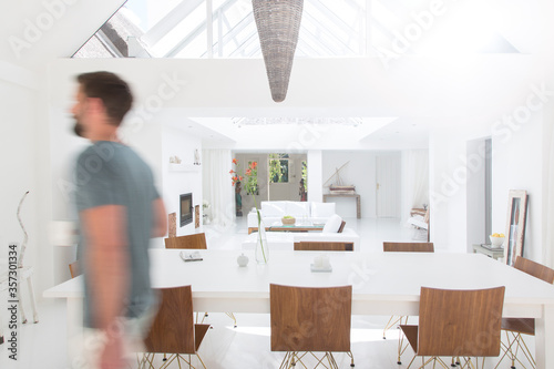 Blurred view of man walking in modern dining room photo