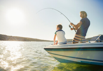Father and son fishing on boat 