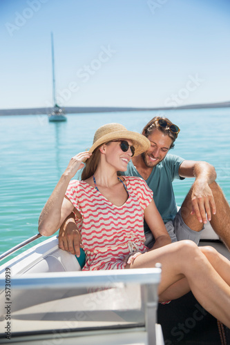 Couple sitting together in boat on water © Robert Daly/KOTO
