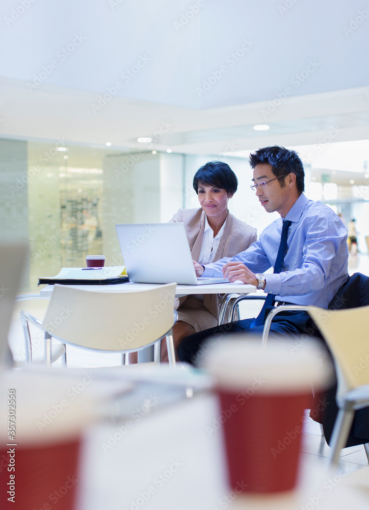 Business people using laptop at table Business people using laptop at table
