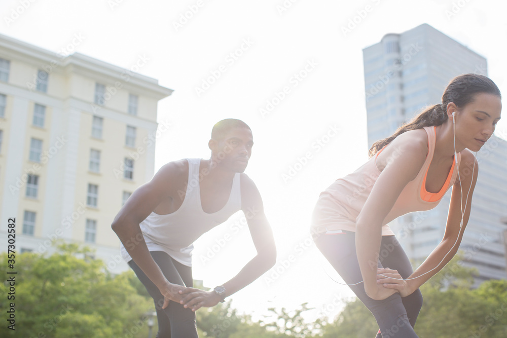 Couple stretching before exercising on city street