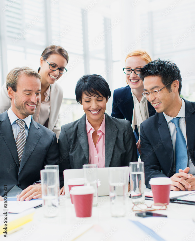 Business people looking at laptop in meeting Business people looking at laptop in meeting