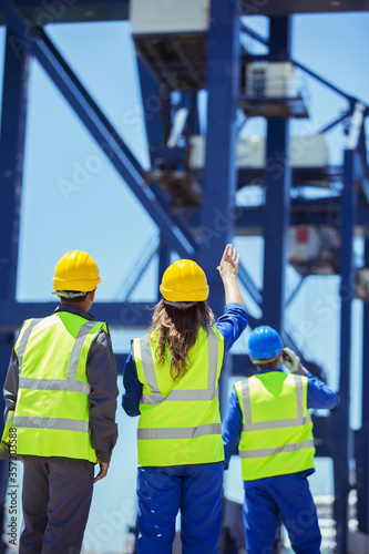 Worker and businessman examining cargo crane