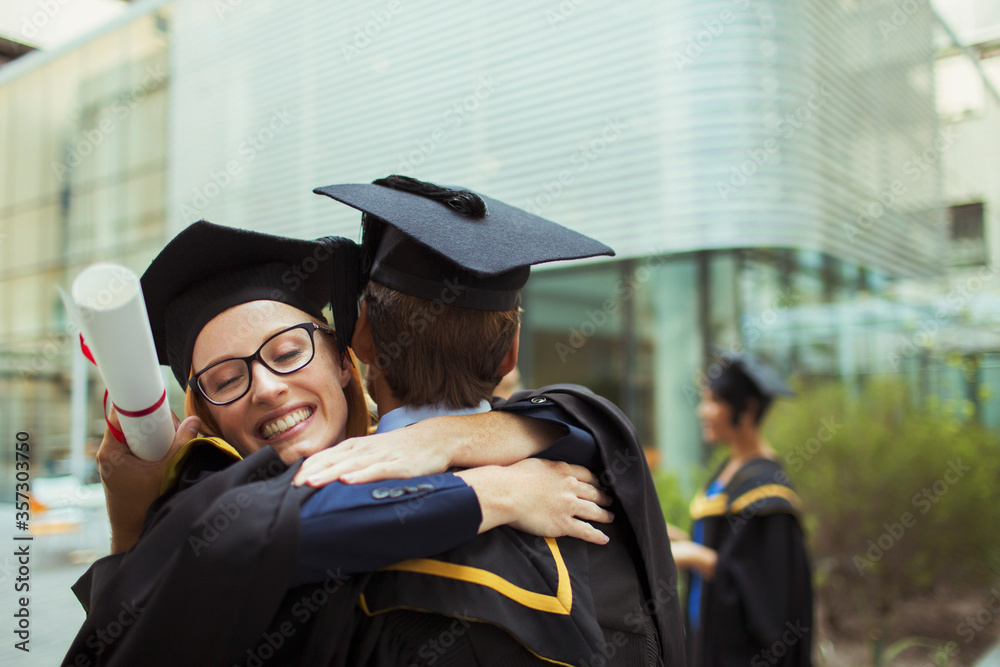 Fototapeta premium Students in cap and gown hugging