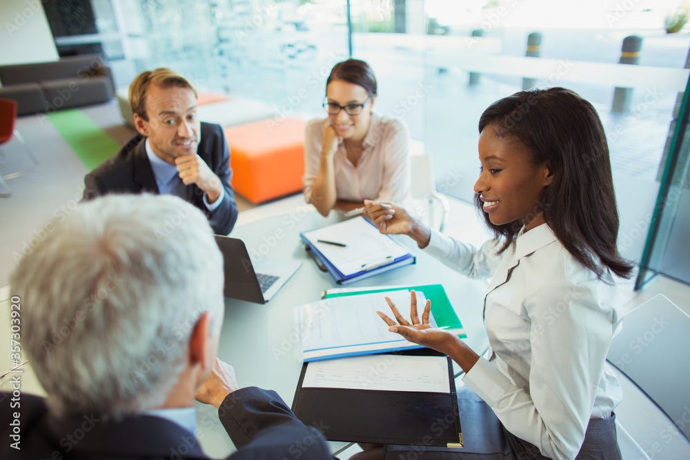Business people talking at table in office building Business people talking at table in office building