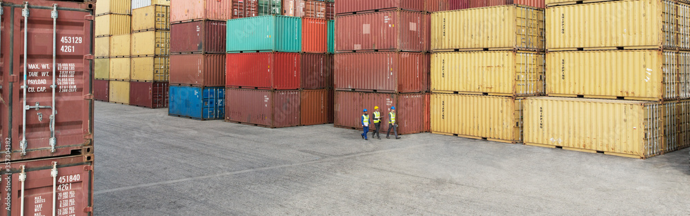 Workers walking near cargo containers Workers walking near cargo containers