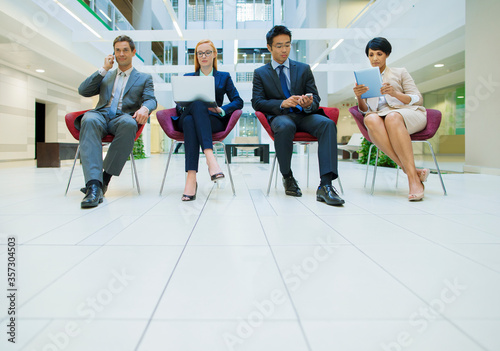 Business people sat in chairs working in office building