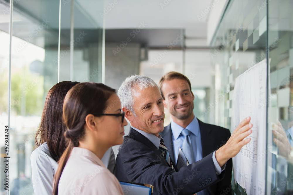 Business people discussing documents in office building Business people discussing documents in office building