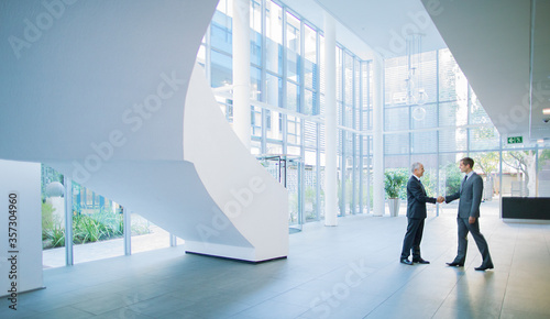 Fotografia Businessmen shaking hands in office building