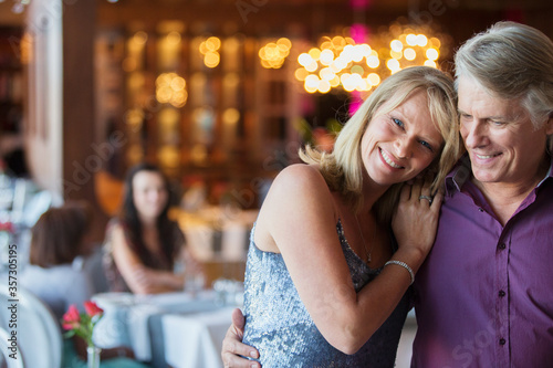 Man embracing woman in restaurant, people in background © Dan Dalton/KOTO