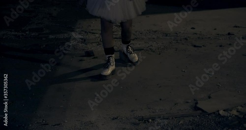 Female Dressed as Scary Clown Dancing in Front of Graffiti Walls photo