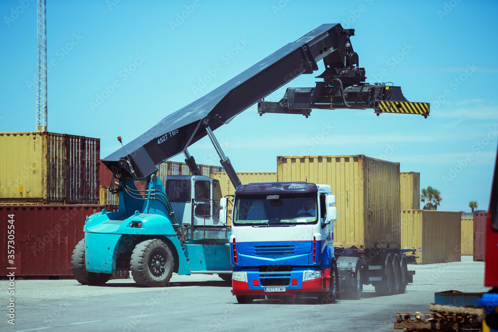 Crane near cargo container on truck Crane near cargo container on truck