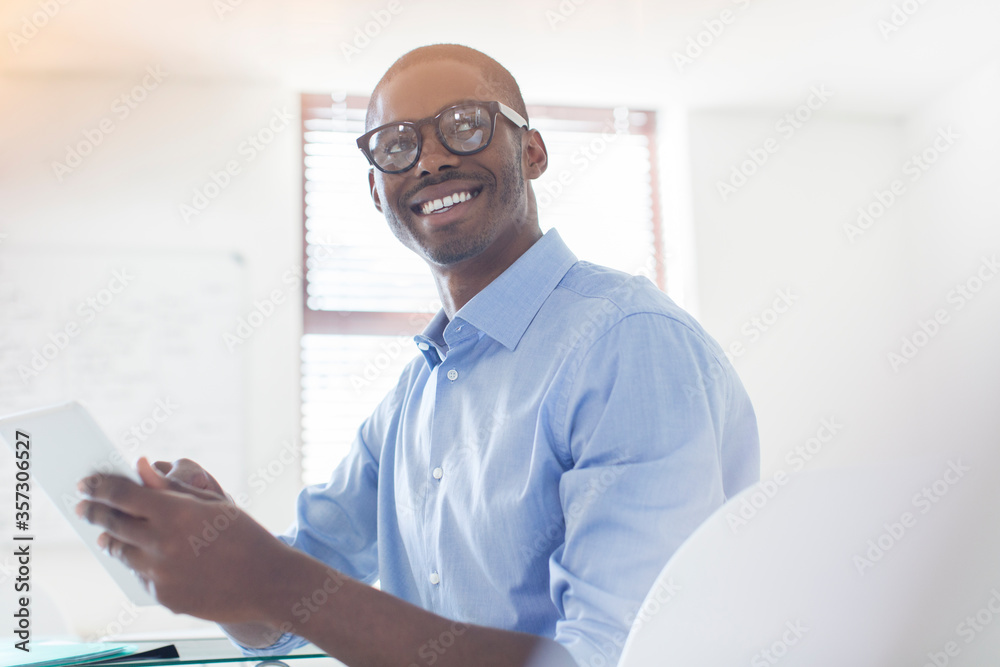 Obraz premium Portrait young businessman wearing glasses blue shirt holding digital tablet in office