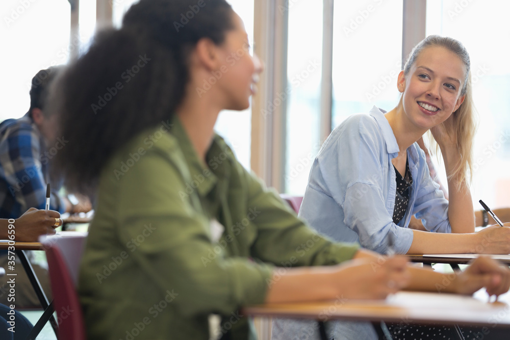 Smiling university students talking in classroom Smiling university students talking in classroom