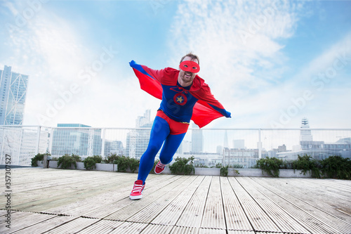 Photos Superhero running with cape on city rooftop